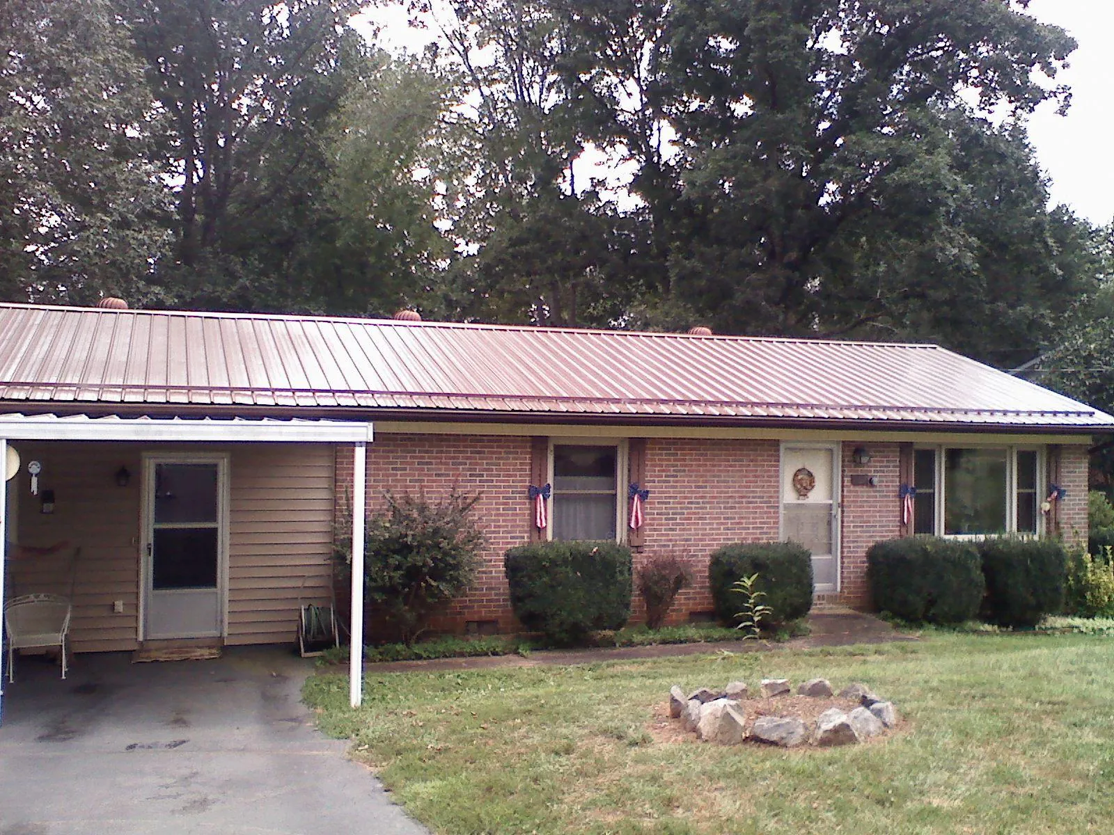 Bronze metal roof and carport on a brick ranch home — Roof Repair work by our crew in Bartow